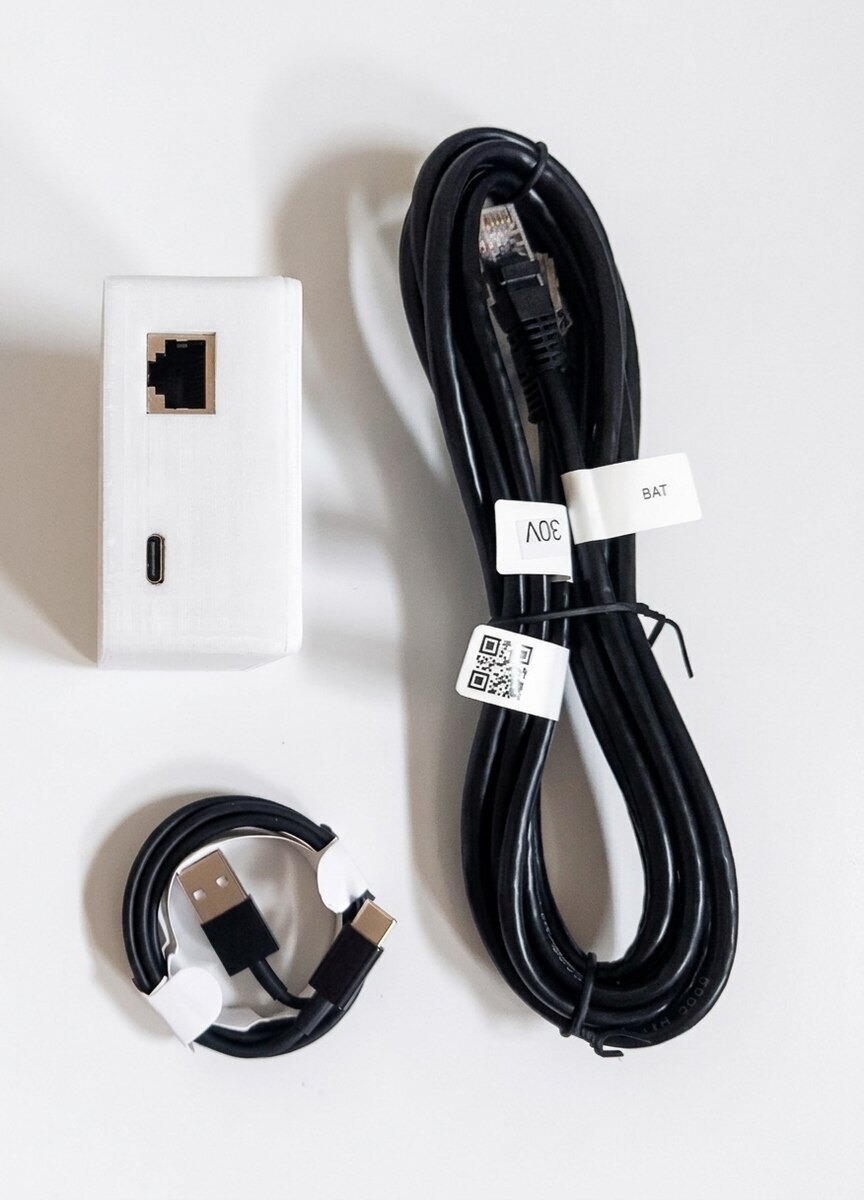 PylonCheck-Box mit RJ45-Konsolenport und USB-C-Port, daneben das beschriftete BAT-Konsolenkabel und das USB-C-Kabel